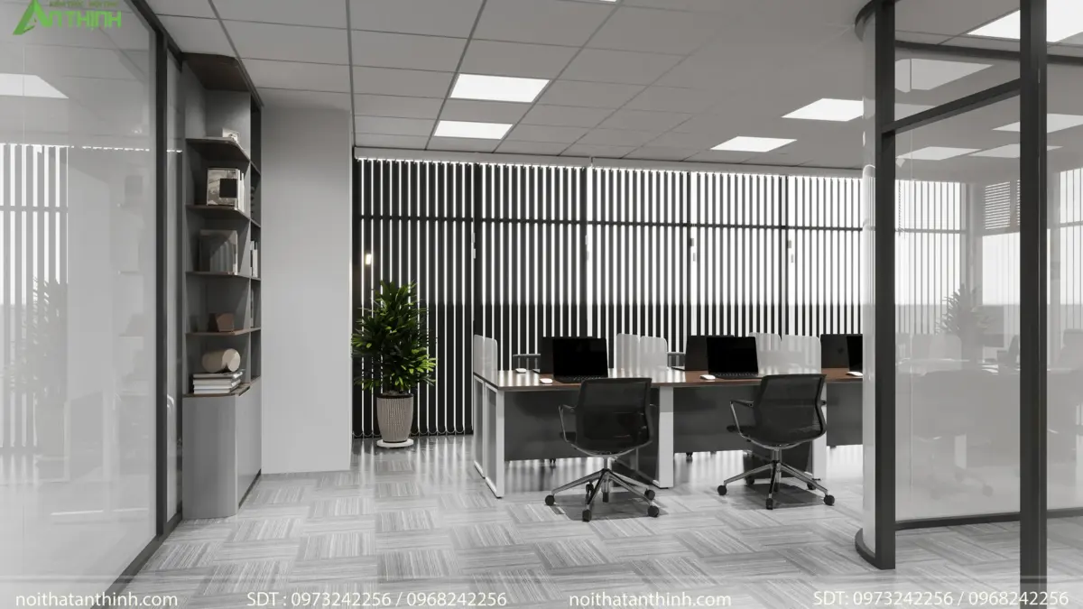 Góc khu làm việc – kệ trang trí gỗ âm tường, vách lam đen đứng tạo riêng tư, cây xanh chậu lớn, cụm bàn đôi nhân viên, ánh sáng đều khắp