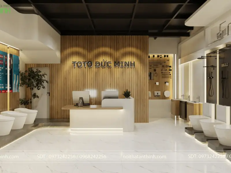 Quầy lễ tân trung tâm – logo TOTO Đức Minh nổi trên vách gỗ óc chó có đèn LED hắt, bồn cầu trưng bày hai bên, bảng phụ kiện treo tường