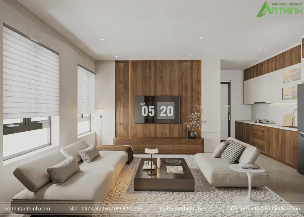 Toàn cảnh phòng khách – bếp liên thông từ góc rộng nhất, thấy đầy đủ sofa trắng, vách tivi gỗ nâu ấm và khu bếp mở phía sau