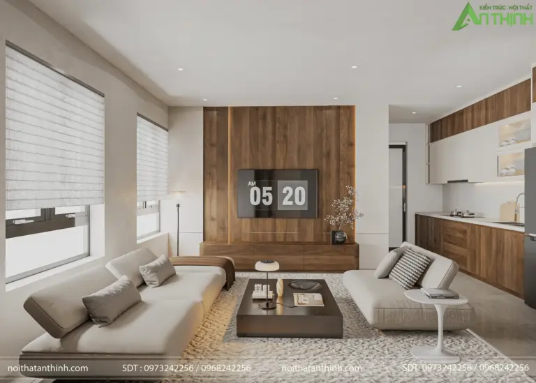 Toàn cảnh phòng khách – bếp liên thông từ góc rộng nhất, thấy đầy đủ sofa trắng, vách tivi gỗ nâu ấm và khu bếp mở phía sau