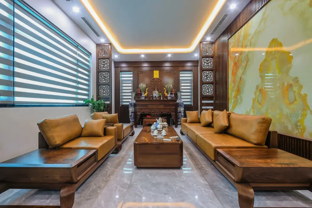 Ảnh thực tế – phòng khách liền phòng thờ, vách thờ gỗ CNC chữ Thọ, sofa gỗ hai bên