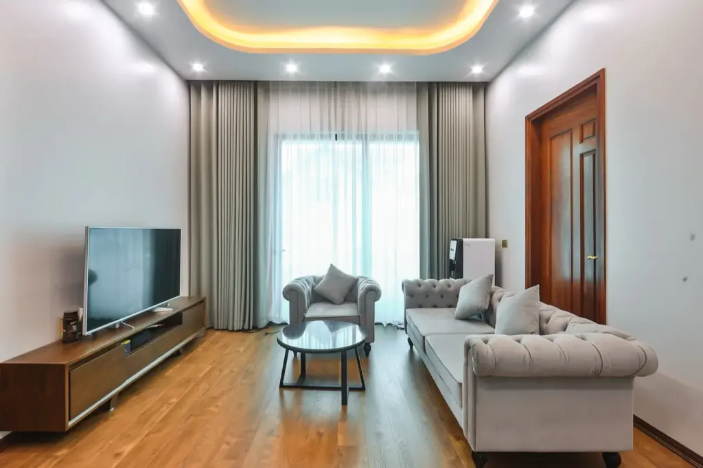 Ảnh thực tế – phòng sinh hoạt chung tầng trên, kệ tivi gỗ thấp, sàn gỗ