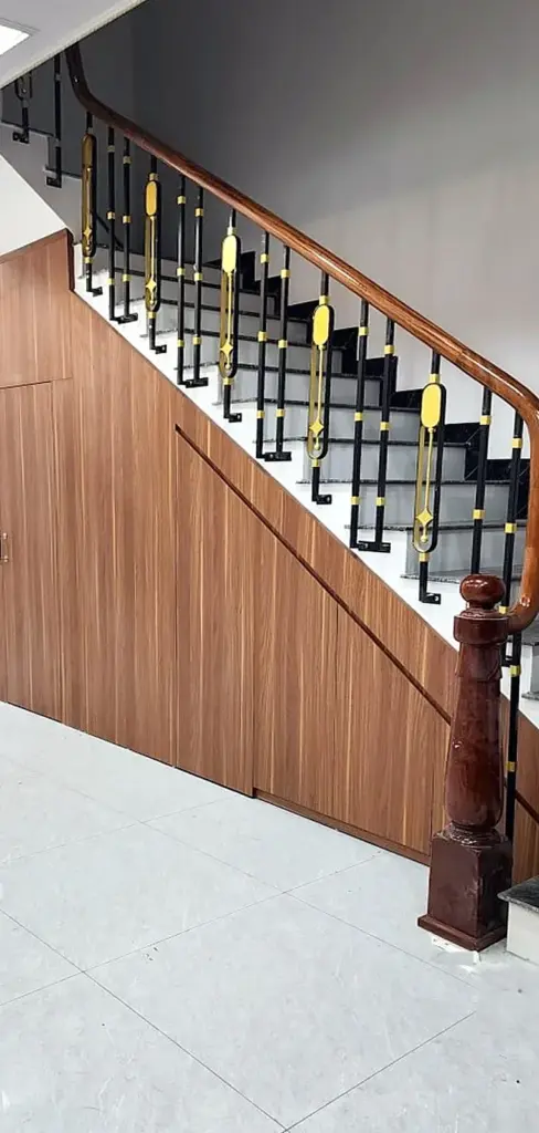 Ảnh thực tế – mảng ốp gầm cầu thang vân gỗ chạy theo đường dốc, cửa WC giấu trong mặt ốp