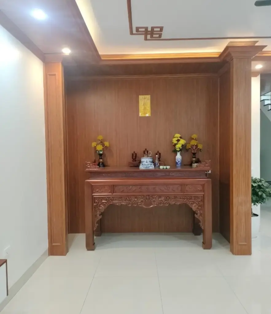 Ảnh thực tế – gian thờ ốp vách gỗ nâu, trụ gỗ hai bên, bàn thờ gỗ chạm