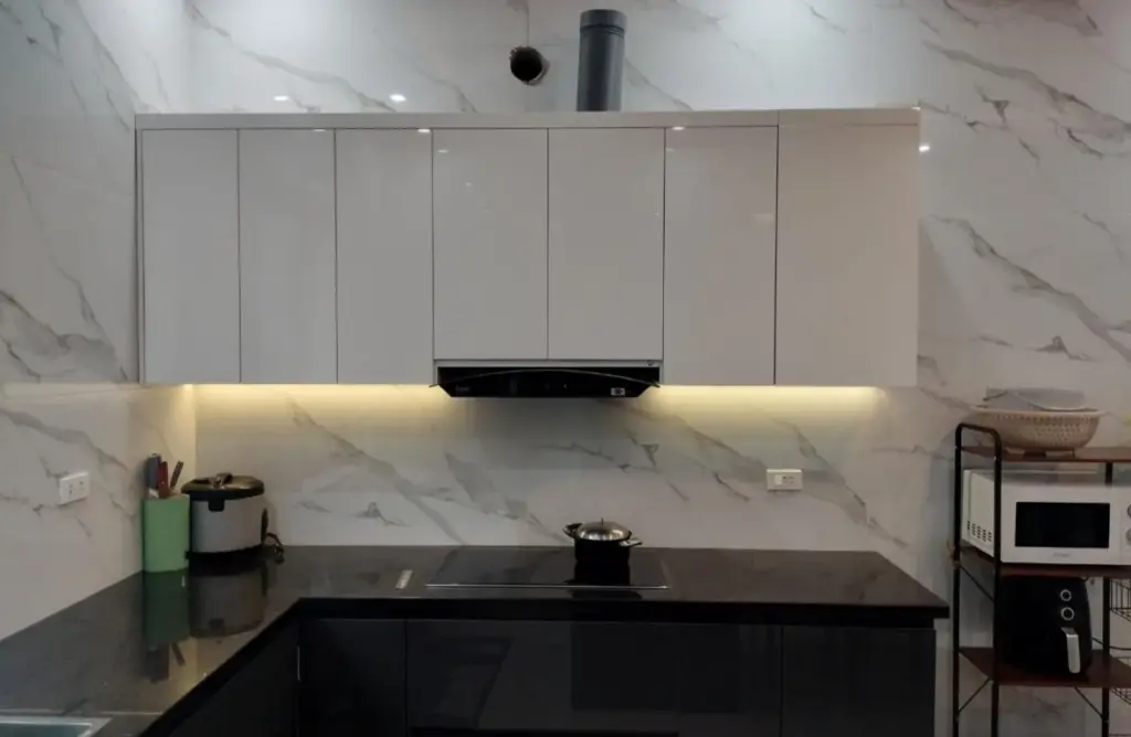 Ảnh thực tế – tủ bếp trên trắng có LED hắt, tường đá vân trắng
