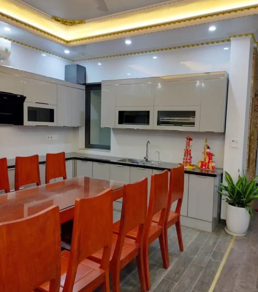 Ảnh thực tế – bếp chữ L tủ trên trắng bóng, lò âm tủ, mặt đá đen