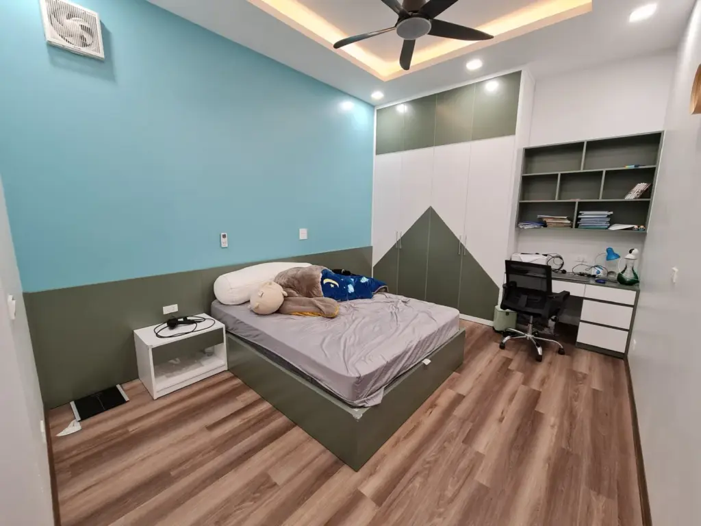 Ảnh thực tế – phòng con tường xanh, giường và tủ hoạ tiết núi