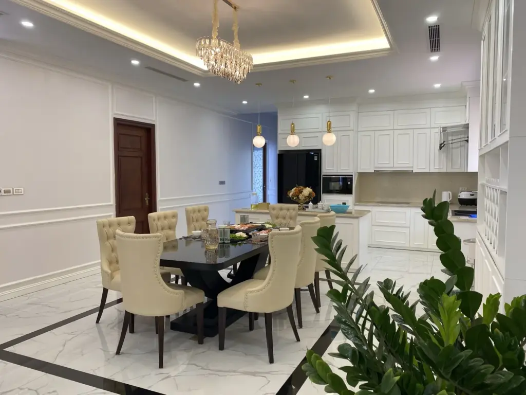 Ảnh thực tế – bàn ăn 8 ghế bọc nệm kem, tủ bát cánh kính kịch trần