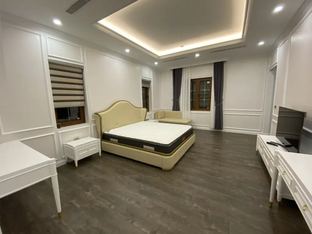 Ảnh thực tế – phòng ngủ tường ốp phào chỉ kem, sàn gỗ tông trầm