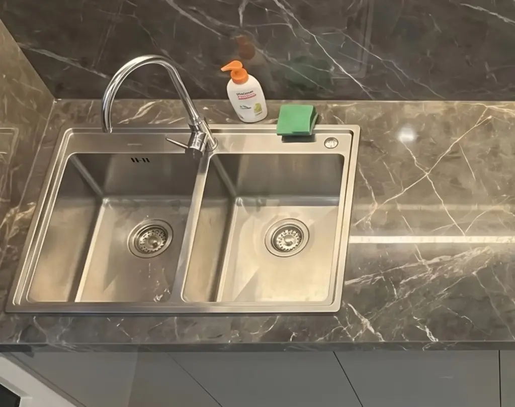 Ảnh thực tế – chậu rửa inox hai hộc, vòi cổ cao trên mặt đá xám vân trắng