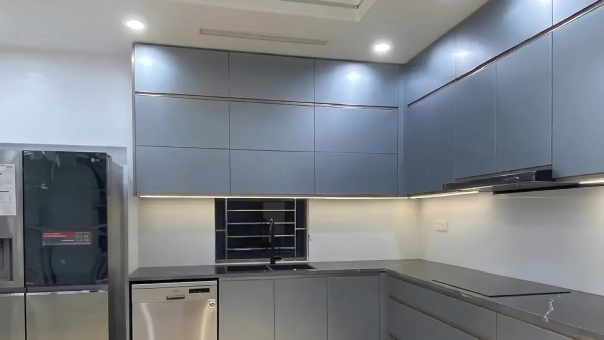 Ảnh thực tế – tủ bếp inox 304 chữ L cánh kính nhám xám xanh, tủ trên kịch trần, máy rửa bát âm tủ