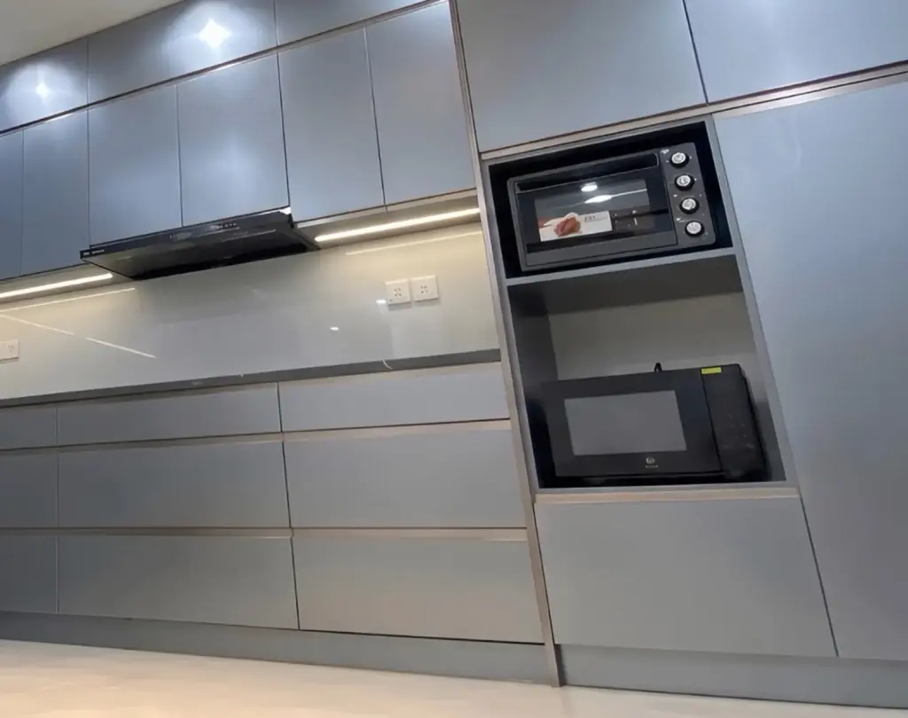 Ảnh thực tế – cột tủ cao âm lò nướng và lò vi sóng, cánh kính xám xanh đồng bộ