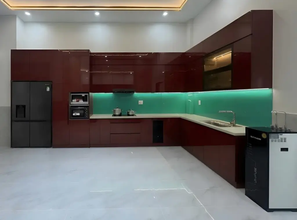 Ảnh thực tế – tủ bếp inox chữ L cánh acrylic đỏ bóng gương, ốp kính xanh có LED, nhà chị Giang, Đan Phượng