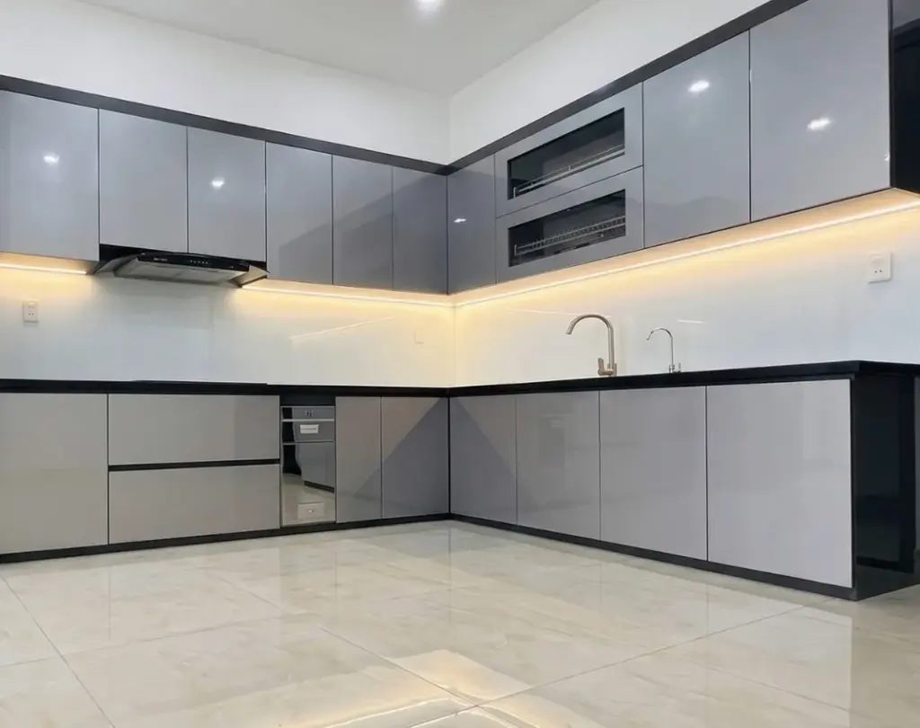 Ảnh thực tế – bếp chữ L acrylic xám bóng gương tay nắm ẩn, nhà chú Bắc, Nam Từ Liêm