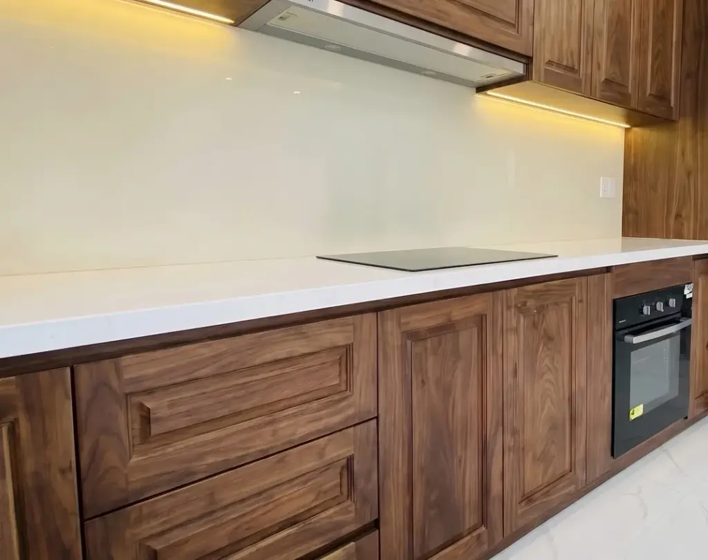 Ảnh thực tế – cận vân gỗ óc chó tủ dưới, đèn LED hắt dưới tủ trên