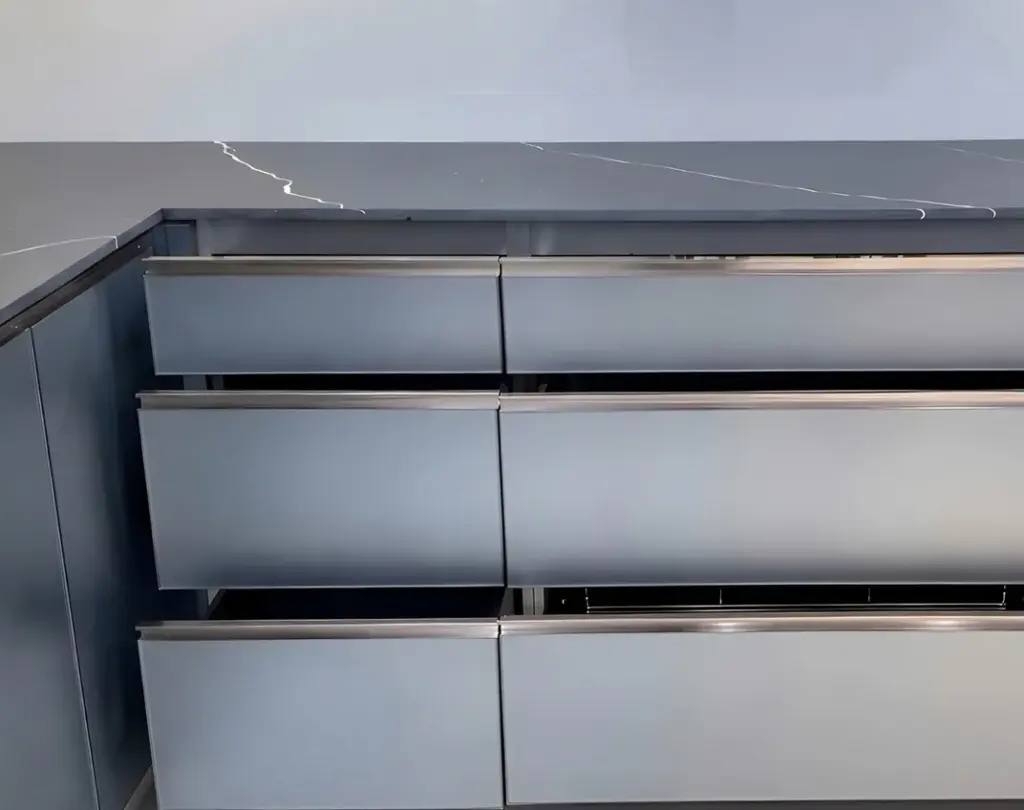 Ảnh thực tế – ngăn kéo lớn cánh kính nhám viền inox dưới mặt đá xám