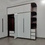 Ảnh thực tế – tủ quần áo mở cánh: khoang treo lót vân gỗ tối, ngăn kéo phía dưới, ô chăn màn phía trên